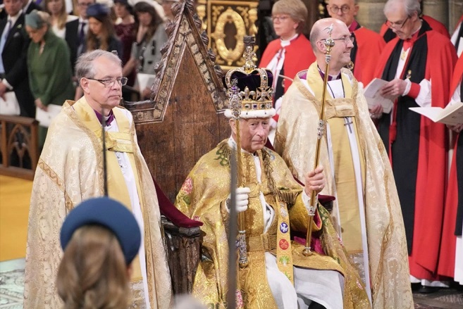 King Charles wearing the crown jewels during coronation.